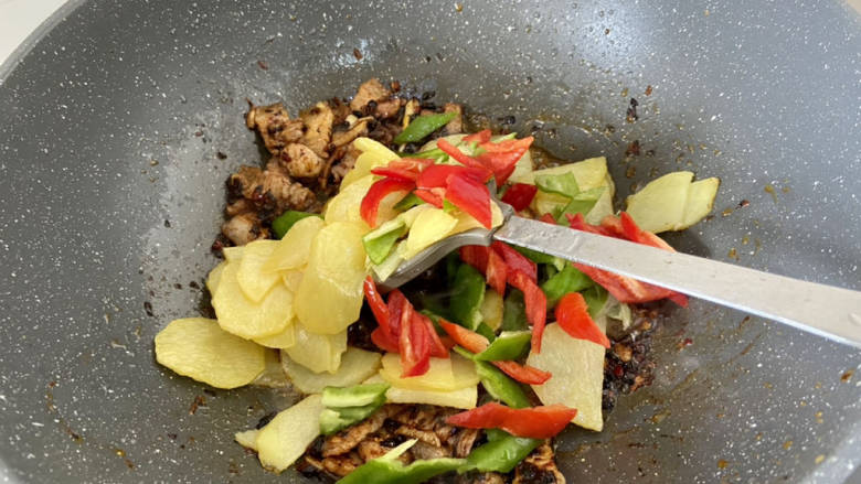 土豆回锅肉,加入土豆片青红椒,中火翻炒到辣椒断生