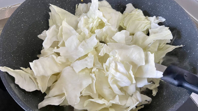 干煸圆白菜,加入圆白菜,转大火,不停翻炒,约两分钟,不要怕糊锅