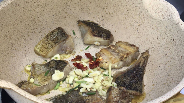 青椒木耳烧鱼块,放入葱姜蒜和干红辣椒碎,炒出香辣味,再翻炒均匀