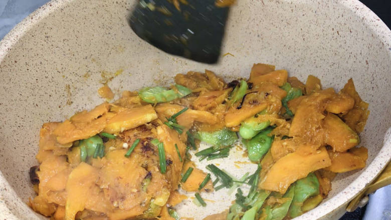 辣椒干炒南瓜,撒上葱花,翻炒均匀