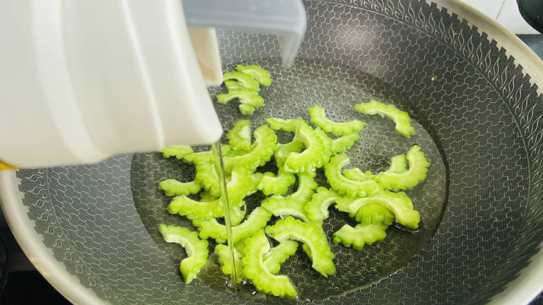 沙白苦瓜汤,锅中加入适量清水大火烧开,加入少许盐和食用油,放入苦瓜焯烫一下,去除苦味。