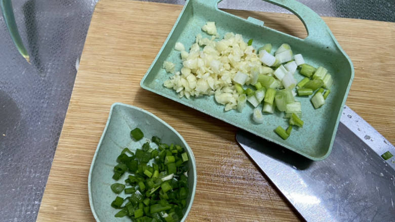 孜然煎豆干,蒜剥皮切末,小葱洗净葱白葱叶分别切末
