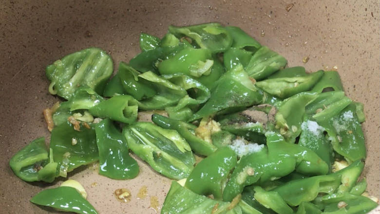 青椒炒牛肉片,放入青椒炒匀,加盐炒匀