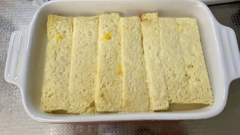法式牛奶烤吐司,倒入准备好的鸡蛋牛奶,稍微按压吐司,让其吸收牛奶
