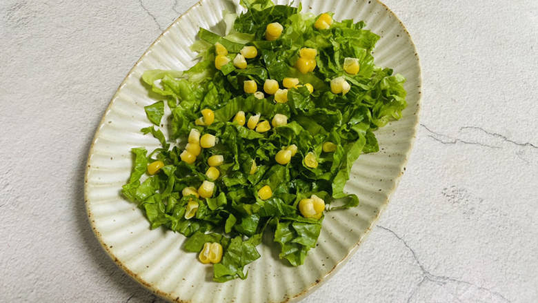 鸡胸肉蔬菜沙拉,将生菜码入盘中,撒上玉米粒