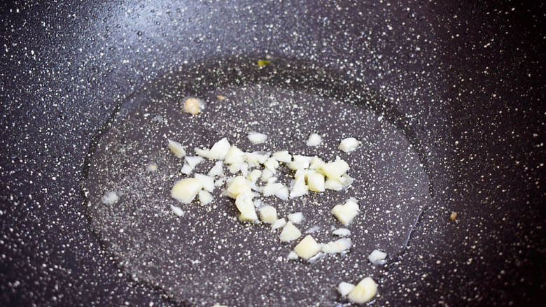 茼蒿炒肉丝,原锅倒入适量的食用油烧热,放入蒜末爆香