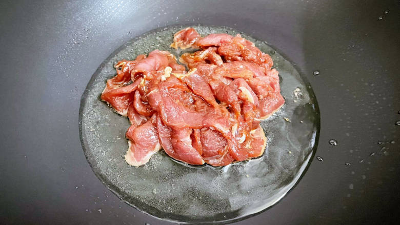 香菇肉片煲,锅中倒入适量的食用油烧热,放入猪肉,翻炒至变色变白