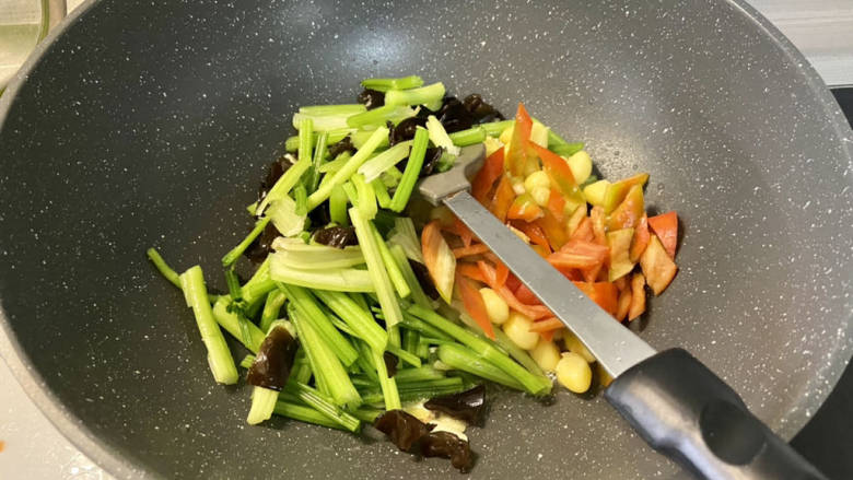 炒白果芹菜,下芹菜木耳白果红椒,中大火翻炒半分钟