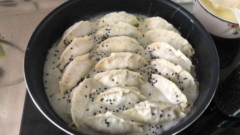 牛肉锅贴➕牛肉芹菜锅贴,浇上适量的面水,约没过生煎1/3,撒上一些熟黑芝麻。