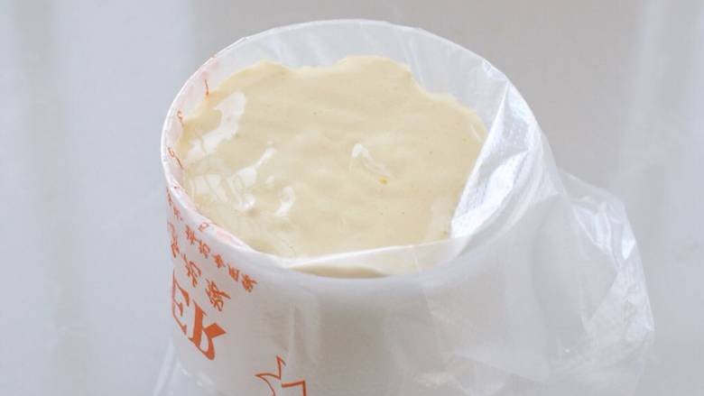 草莓抱抱卷,裱花袋剪口装入圆形裱花嘴,套在杯子上,再把面糊倒入裱花袋中。