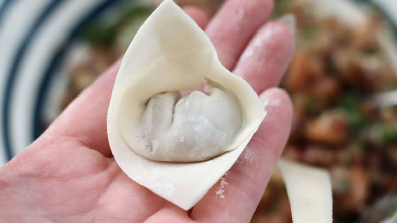 洋葱海米小馄饨,卷起两边捏紧,全部包好后。