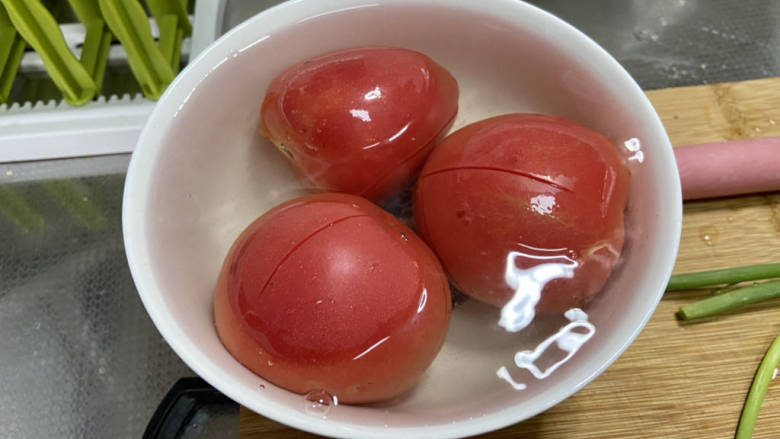 番茄黄瓜炒蛋,番茄清洗后表面化十字花刀,开水浸泡三分钟,方便去皮