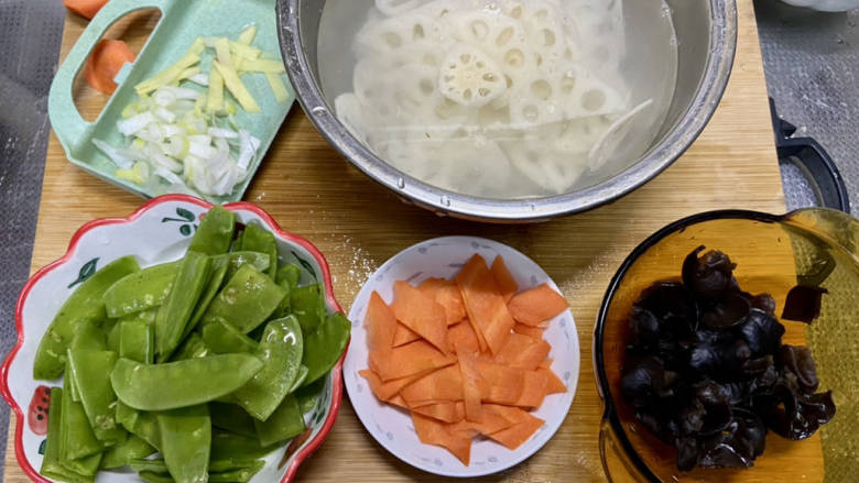 荷兰豆藕片,姜切片，葱白切末，莲藕切片清水浸泡以免氧化变黑，荷兰豆中比较大的可以一切为二，胡萝卜切薄片，木耳撕小朵