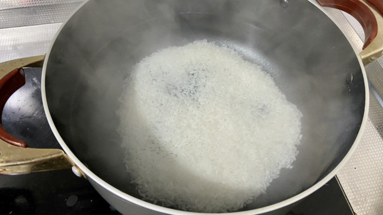 皮蛋火腿粥,锅中加入两升水,煮开后加入粳米