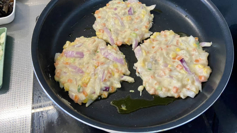 鲜虾蔬菜饼➕鲜虾洋葱胡萝卜玉米小饼,平底锅(电饼铛更好)加热,刷一层食用油,舀取面糊,整理成小饼状,表面撒少许黑芝麻,小火煎一两分钟到底面定型焦黄