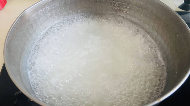 皮蛋火腿粥,大火煮沸转中小火慢煮二十分钟,期间用汤勺搅拌数次,防止粘锅底