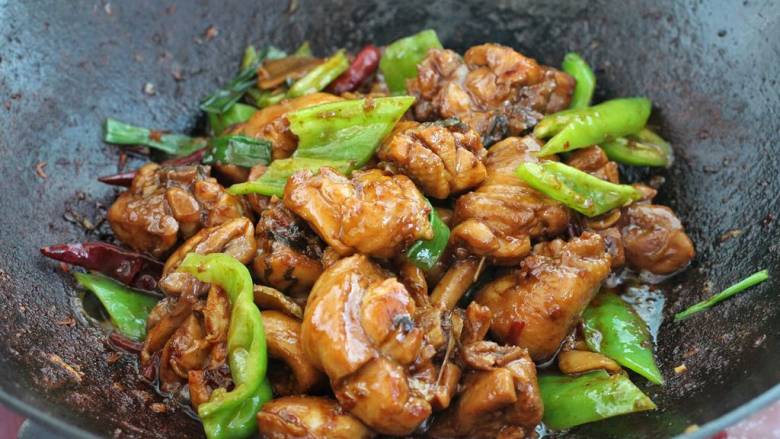 酱炒鸡块,待鸡肉熟烂后加入尖椒和葱叶,大火翻炒收汁即可。