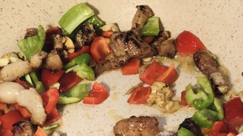 豌豆米炒肉,放入青红辣椒炒匀,加盐炒入味