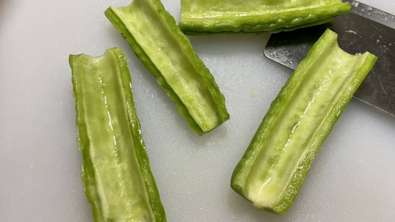 苦瓜炒藕,苦瓜搓洗干净,纵切,用勺子刮干净白瓤,清洗备用。一定要刮干净,这个瓤是最苦的
