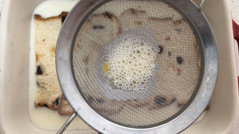 法式牛奶烤吐司,然后将牛奶鸡蛋液过滤,倒入烤盘中。