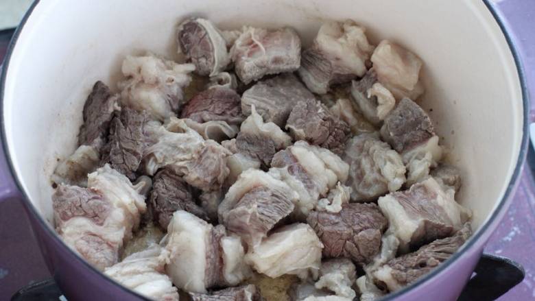 红焖牛肉煲,锅中倒入适量食用油烧热,下牛肉翻炒变色断生。