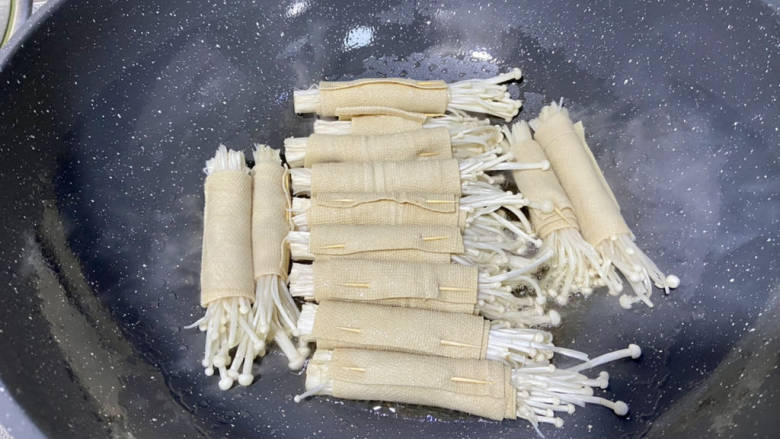 金针菇豆皮卷,热锅后加适量食用油,摆入豆皮金针菇卷,中小火煎