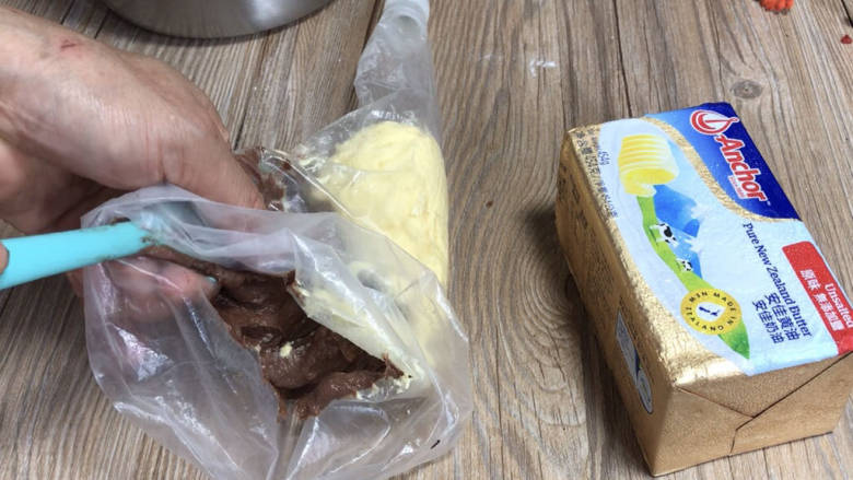 双色黄油曲奇,装入裱花袋内的另一边，再用手在裱花袋外面满满挤匀，使两种颜色的曲奇糊在里面各占一半（同时200度预热烤箱10分钟）