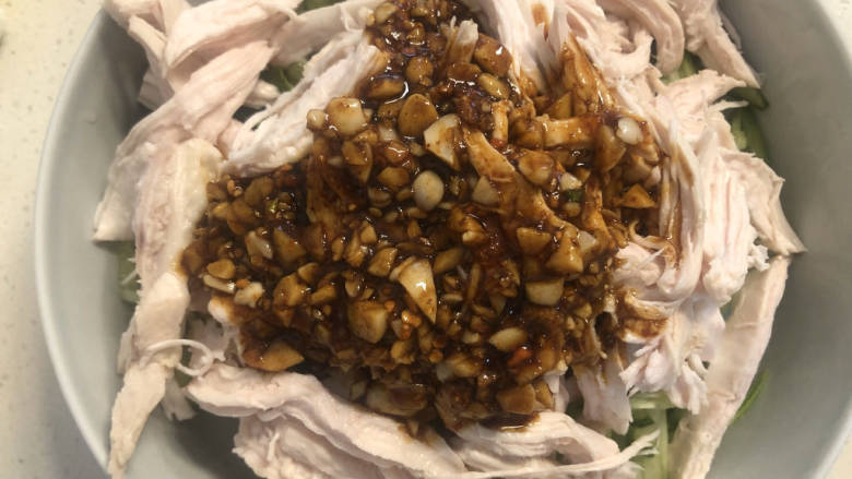 椒麻手撕鸡,最后将料汁淋在鸡肉上面,拌匀即可。