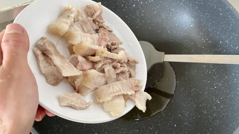 土豆回锅肉,热锅后加入少许食用油,下肉片,中小火煸炒出油