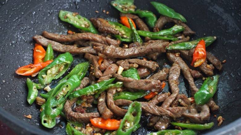 青椒爆炒牛里脊,最后把炒好的牛肉倒回锅中,混合翻炒均匀盛出即可。