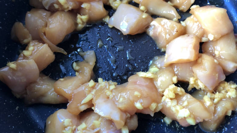 杏鲍菇炒鸡丁,起油锅下入鸡丁,翻炒至变色。