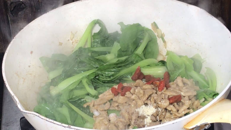 小白菜炒肉丝,加入肉丝、枸杞、盐、胡椒粉和鸡精,翻炒均匀