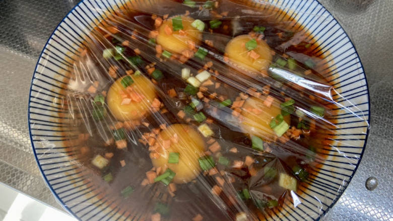 酱卧鸡蛋,蒙上保鲜膜,用牙签戳一些小眼