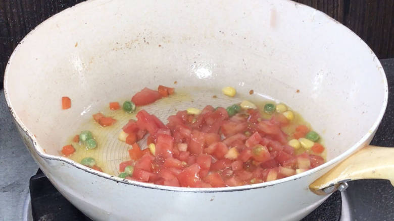 番茄里脊,放入玉米粒、青豆和胡萝卜丁,炒熟,放入番茄炒匀至熟烂