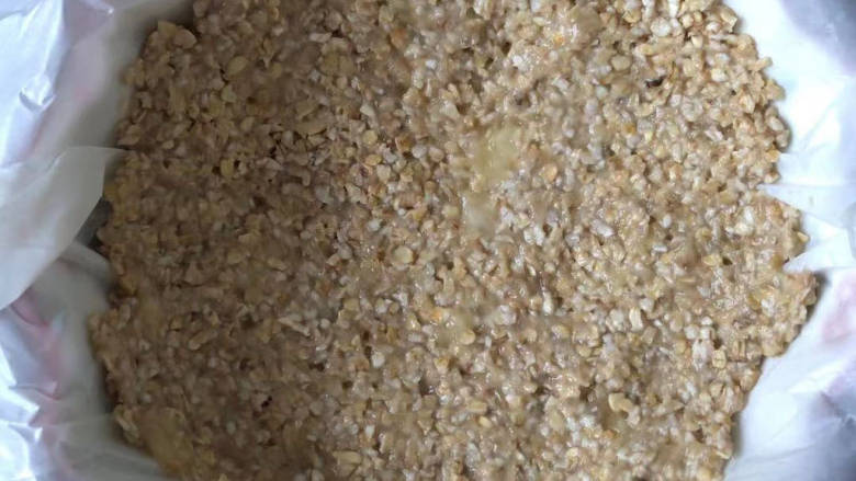 苹果燕麦派,把燕麦香蕉泥铺在碗里,按压紧实。