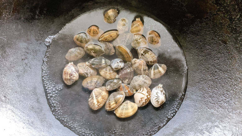 凉拌花甲,入锅中汆烫，烫到花甲“咧开嘴”，而后捞出待用