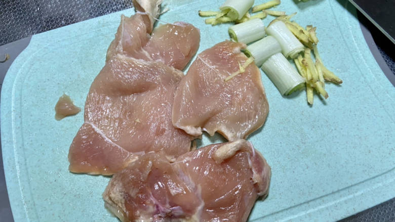 鸡胸肉蔬菜沙拉,鸡胸肉清洗,吸干水分,鸡胸肉比较厚,从中间片开,用叉子在表面均匀戳满小洞,方便腌制入味。葱白切段,姜切丝