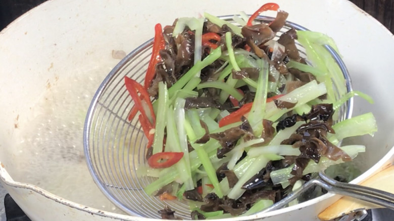 芹菜木耳炒肉丝,加入红椒丝拌匀,捞出沥水备用
