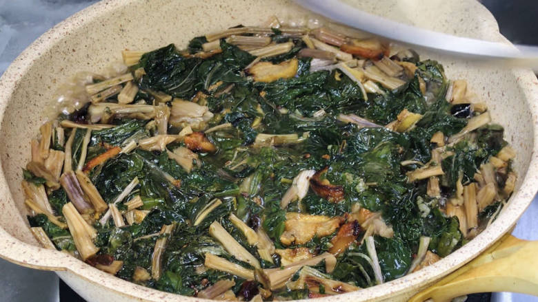 家常焖梅干菜,加入适量清水,煮沸后转中火,盖上锅盖炖煮20分钟左右