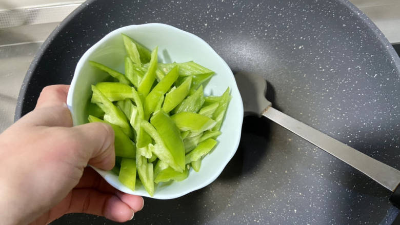 辣椒豆腐干小炒肉,锅中不放油，热锅后加入青椒，中火炕到表面起虎皮，炒出辣椒香气，盛出备用