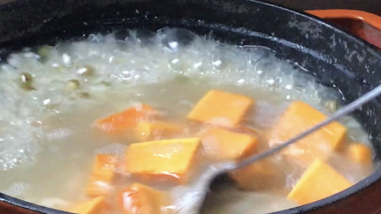 绿豆南瓜粥,加入南瓜拌匀,大火煮沸后转中火继续煮20分钟