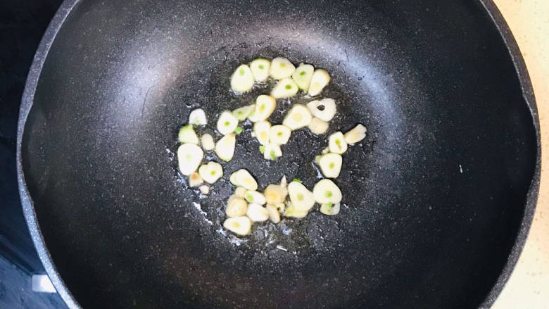 芹菜炒墨鱼,起油锅,加入蒜片爆香