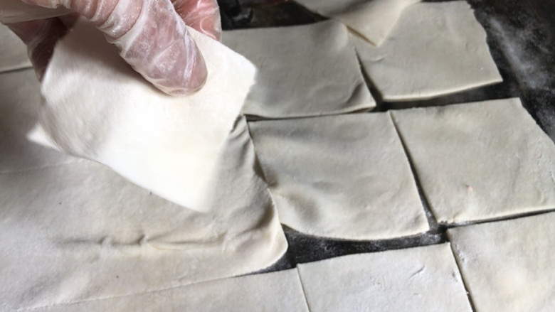 海鲜小馄饨,醒好的面条再揉匀至光滑,用擀面杖擀成整块的大面皮,切成比饺子皮小点的小方块