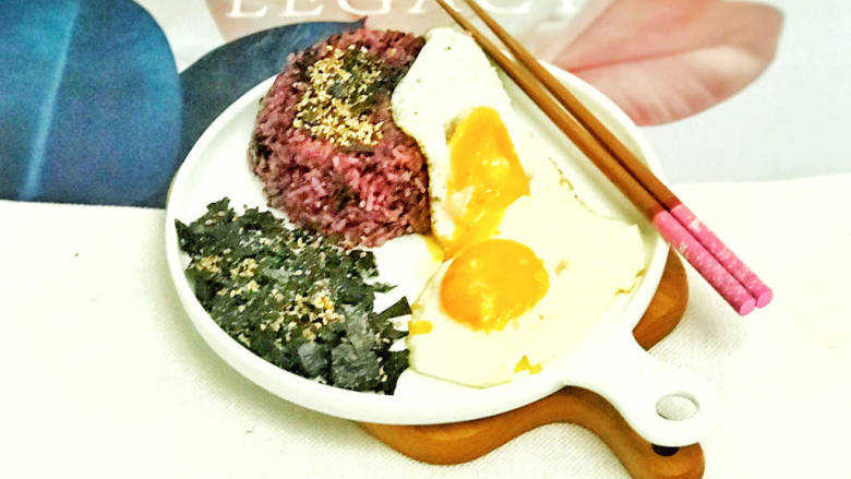 海苔拌饭,将油煎鸡蛋码放在米饭上,装入海苔芝麻碎