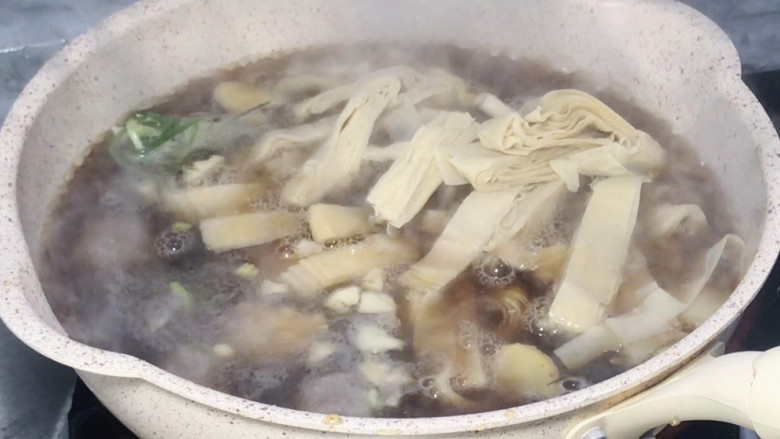 三圆锅,加入丸类和豆腐皮,煮沸至豆腐皮软绵