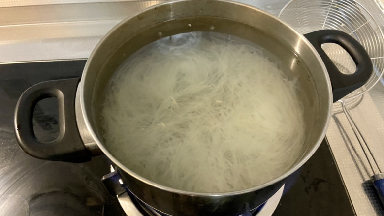 凉拌粉丝黄瓜,泡好的粉丝用剪刀剪两半,方便夹取。坐锅烧水,水开下粉丝,烫半分钟,捞出过凉开水