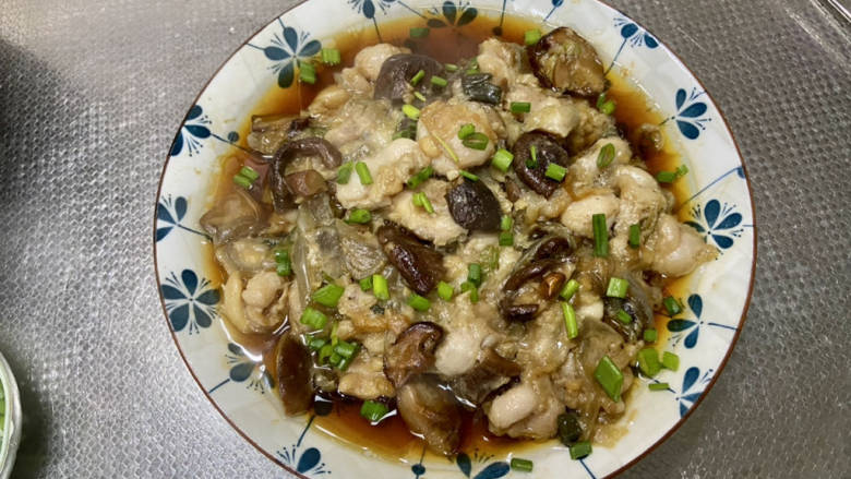 姜葱冬菇蒸滑鸡,取出,撕去保鲜膜,撒葱末即可上桌享用