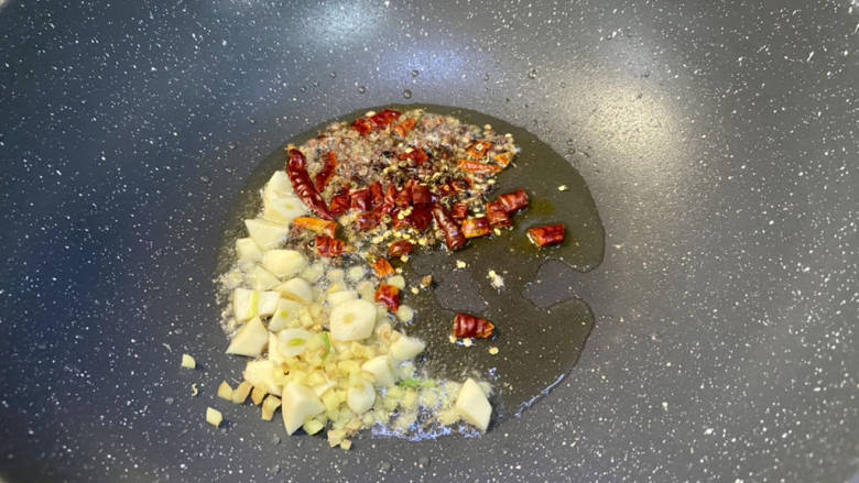 干锅鸭掌,鸭掌卤好检出,锅洗净,重新烧热,加入适量食用油,加入蒜粒姜粒,干辣椒花椒,中小火煸香