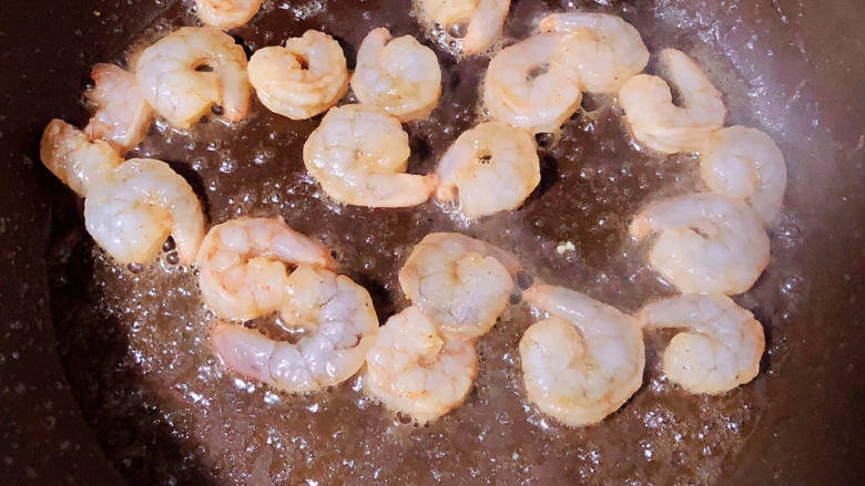 玉米虾仁蛋炒饭,锅中倒入少许油,下入虾仁炒至变色。