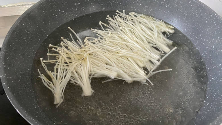 金汤鱼,坐锅烧水,水开下金针菇烫煮两分钟捞出